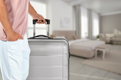 Image of Man with suitcase in hotel room, closeup