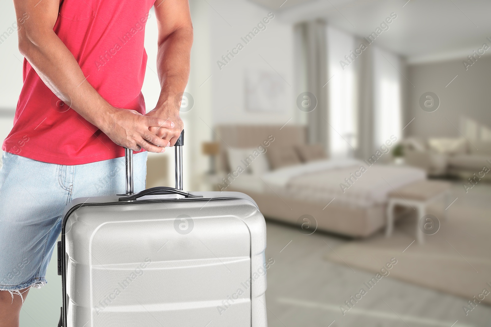 Image of Man with suitcase in hotel room, closeup
