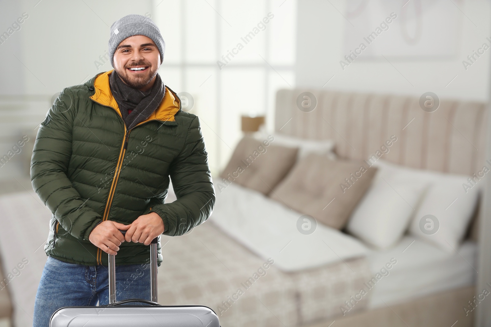 Happy man with suitcase in hotel room Image of Happy man with suitcase in hotel room