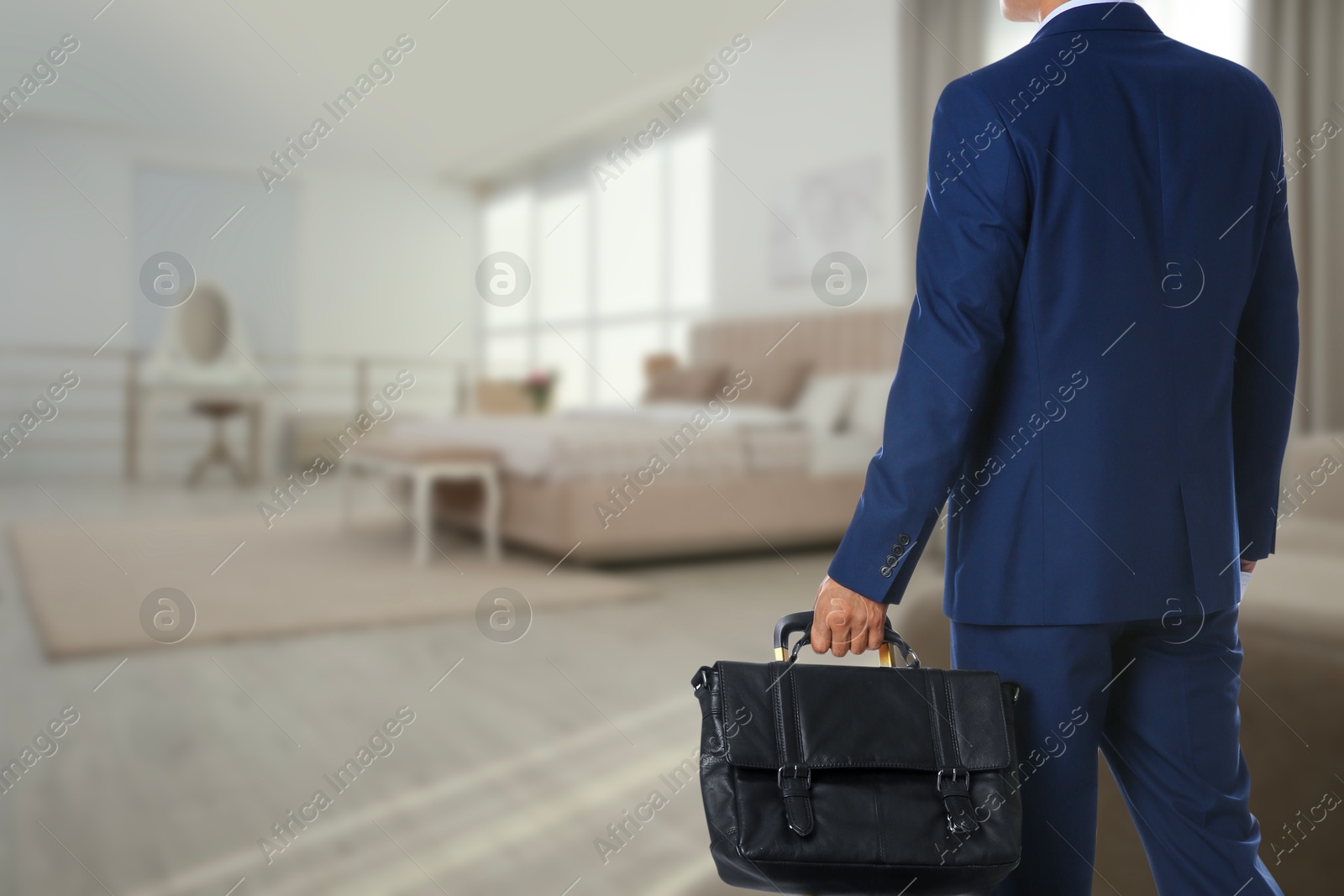 Image of Businessman with bag in hotel room, closeup. Guest heading to bed
