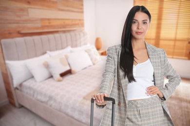 Image of Business woman with suitcase in hotel room