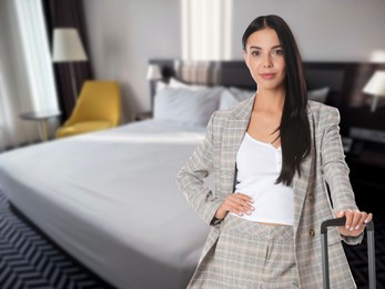 Image of Business woman with suitcase in hotel room