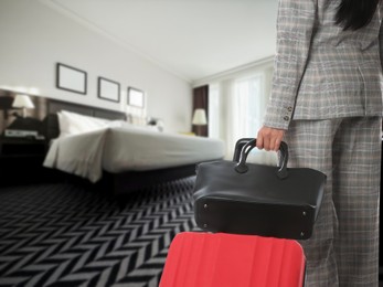 Image of Business woman with suitcase and bag in hotel room, closeup