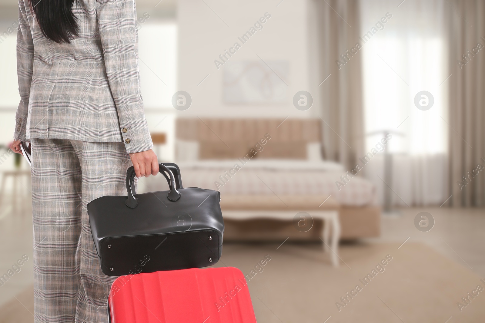 Image of Woman with suitcase and bag in hotel room, closeup