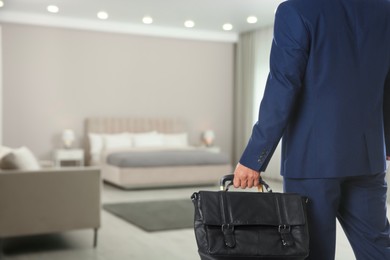 Image of Businessman with bag in hotel room, closeup