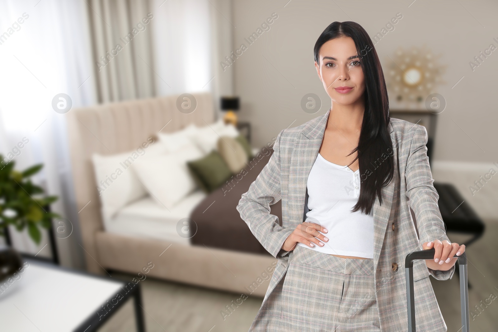 Image of Business woman with suitcase in hotel room