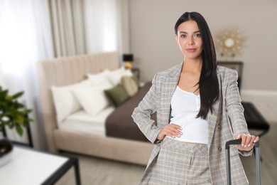Image of Business woman with suitcase in hotel room