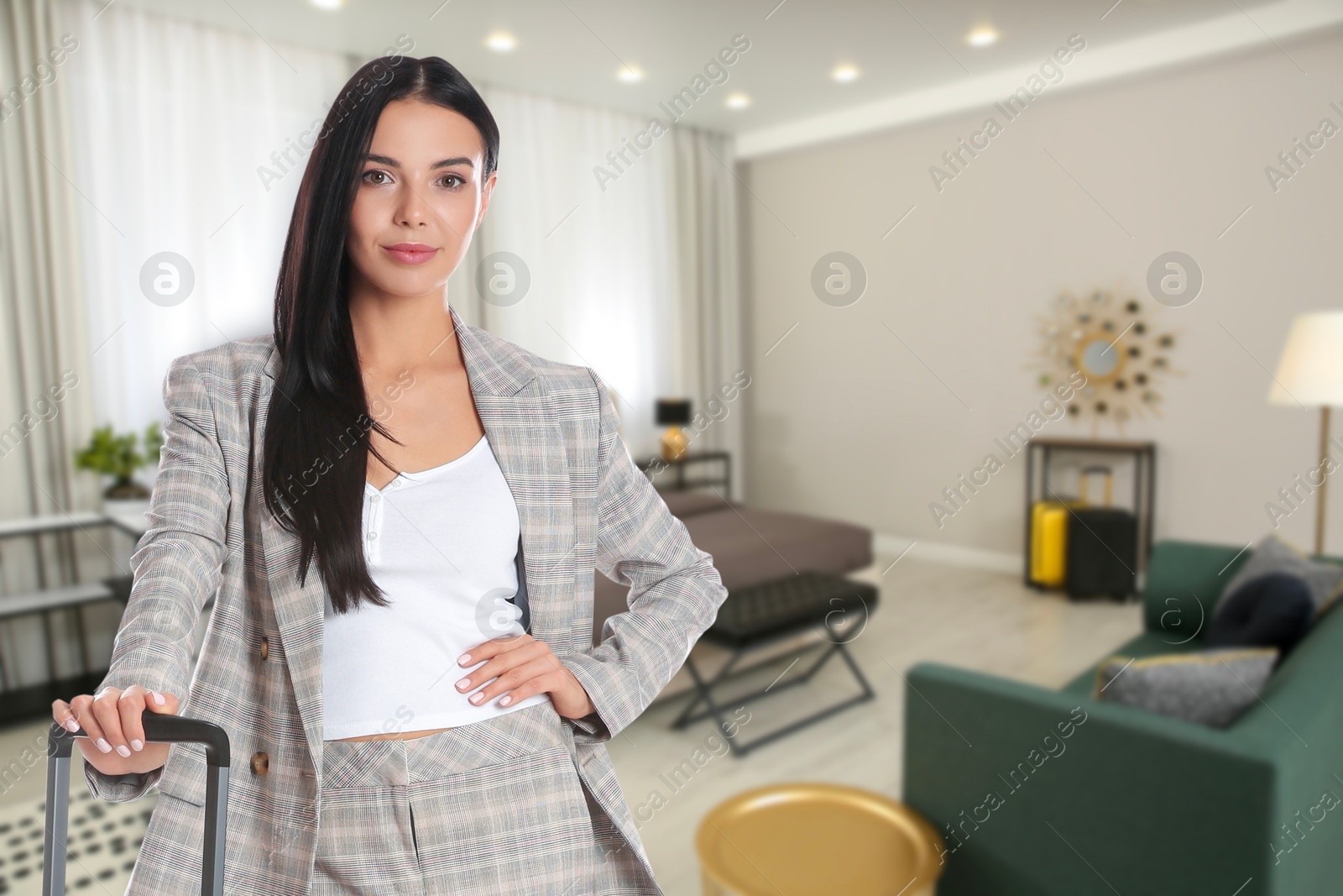 Image of Business woman with suitcase in hotel room