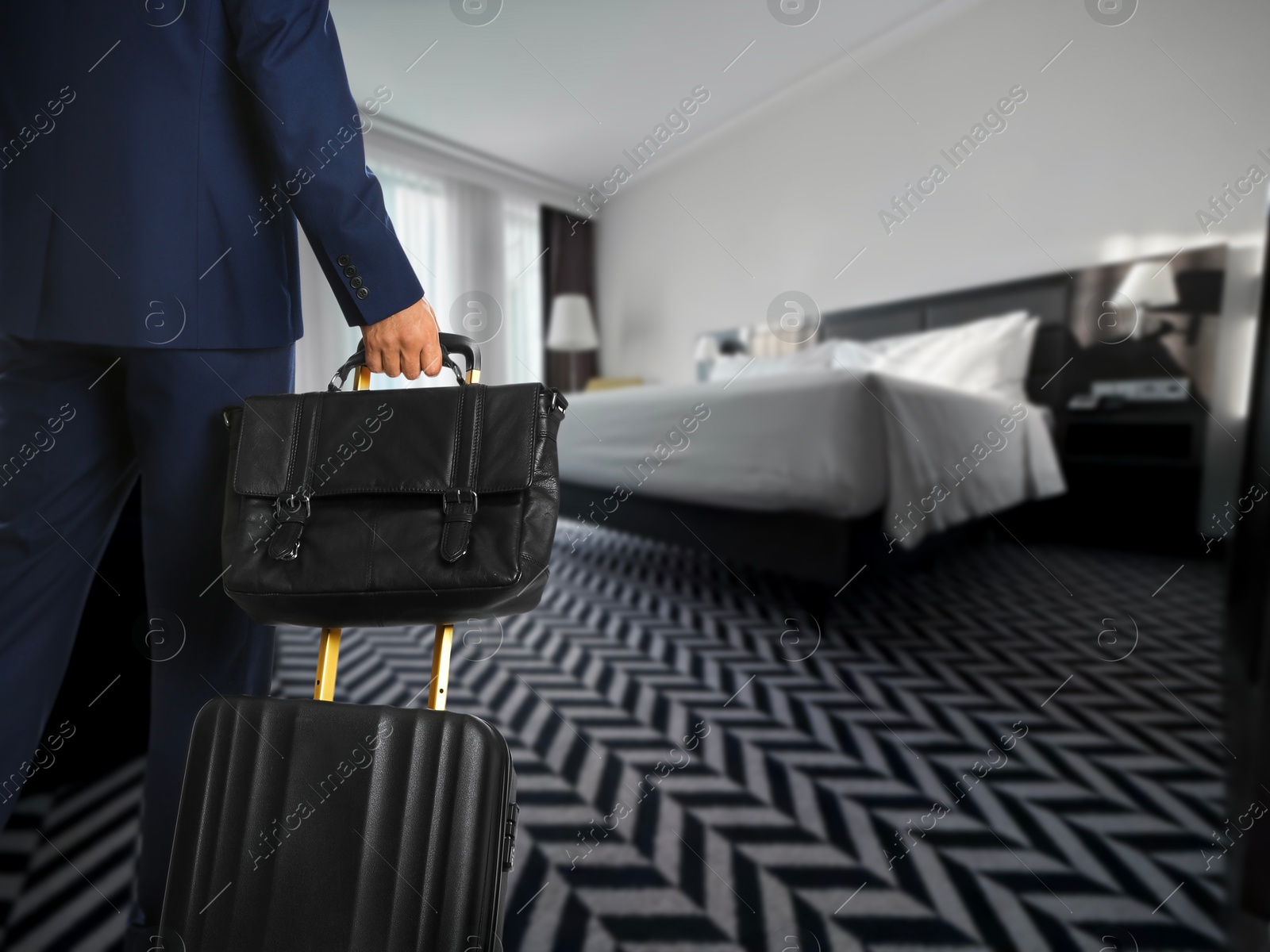 Image of Businessman with suitcase and bag in hotel room, closeup