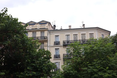 Photo of Beautiful building with windows and trees in city
