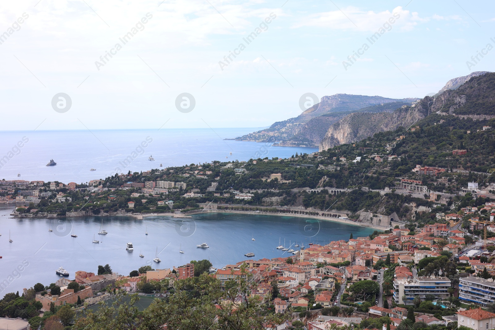 Photo of Picturesque view of city, sea and boats under beautiful sky with clouds