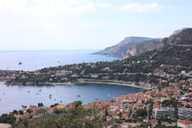Photo of Picturesque view of city, sea and boats under beautiful sky with clouds