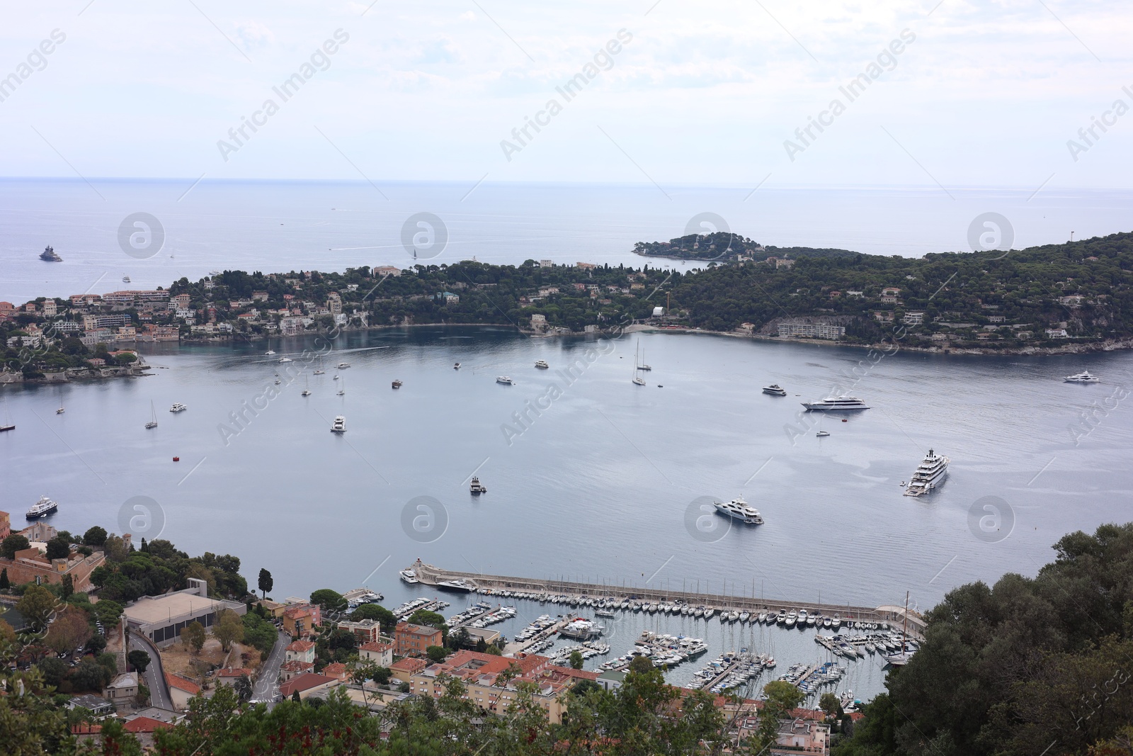 Photo of Picturesque view of city, sea and boats under beautiful sky with clouds