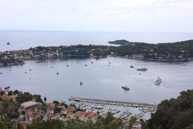 Photo of Picturesque view of city, sea and boats under beautiful sky with clouds
