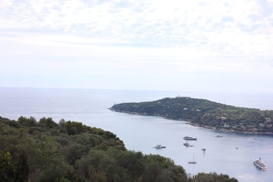 Photo of Picturesque view of city, sea and boats under beautiful sky with clouds