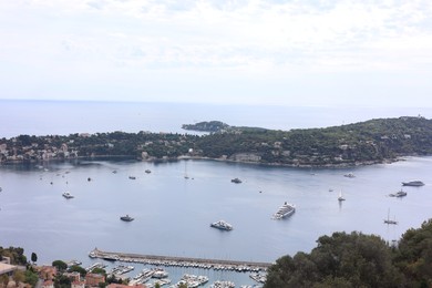 Photo of Picturesque view of city, sea and boats under beautiful sky with clouds