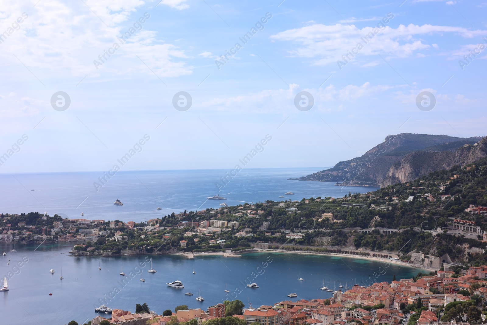 Photo of Picturesque view of city, sea and boats under beautiful sky with clouds