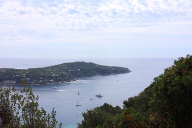 Photo of Picturesque view of city, sea and boats under beautiful sky with clouds
