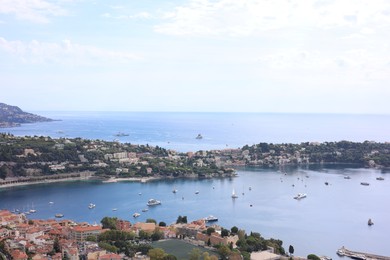 Photo of Picturesque view of city, sea and boats under beautiful sky with clouds