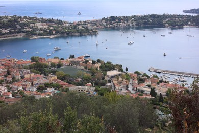 Photo of Picturesque view of city, sea and boats under beautiful sky with clouds
