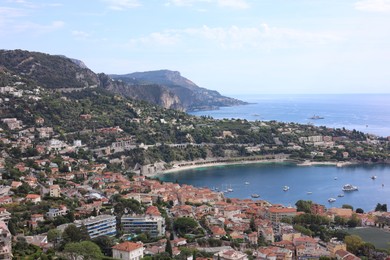 Photo of Picturesque view of city, sea and boats under beautiful sky with clouds