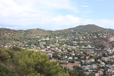 Photo of Picturesque view of city with buildings and trees in mountains