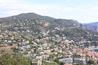 Photo of Picturesque view of city with buildings and trees in mountains