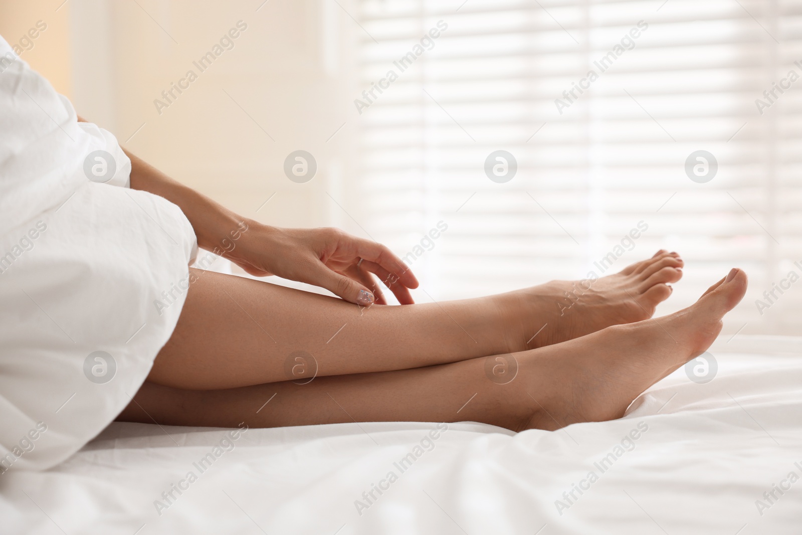 Photo of Woman covering with blanket on bed at home, closeup