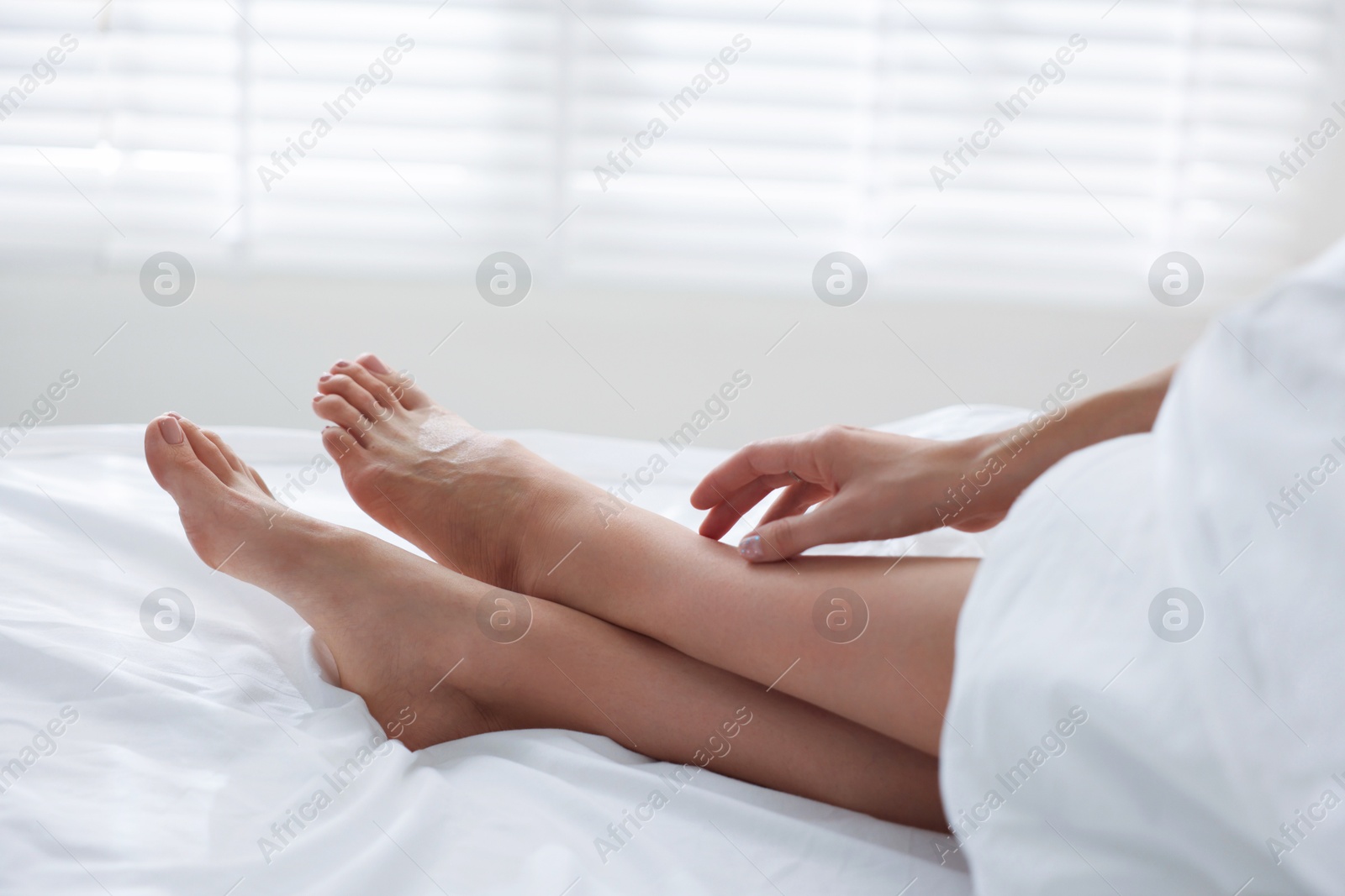 Photo of Woman covering with blanket on bed at home, closeup
