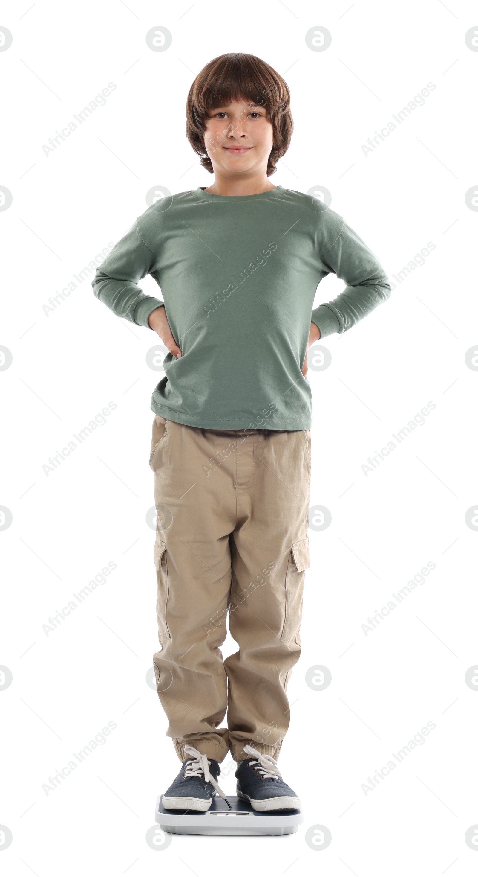 Photo of Little boy standing on scales against white background
