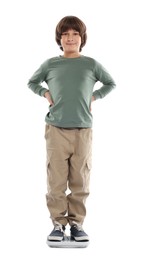 Photo of Little boy standing on scales against white background