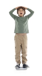 Photo of Emotional boy standing on scales at home