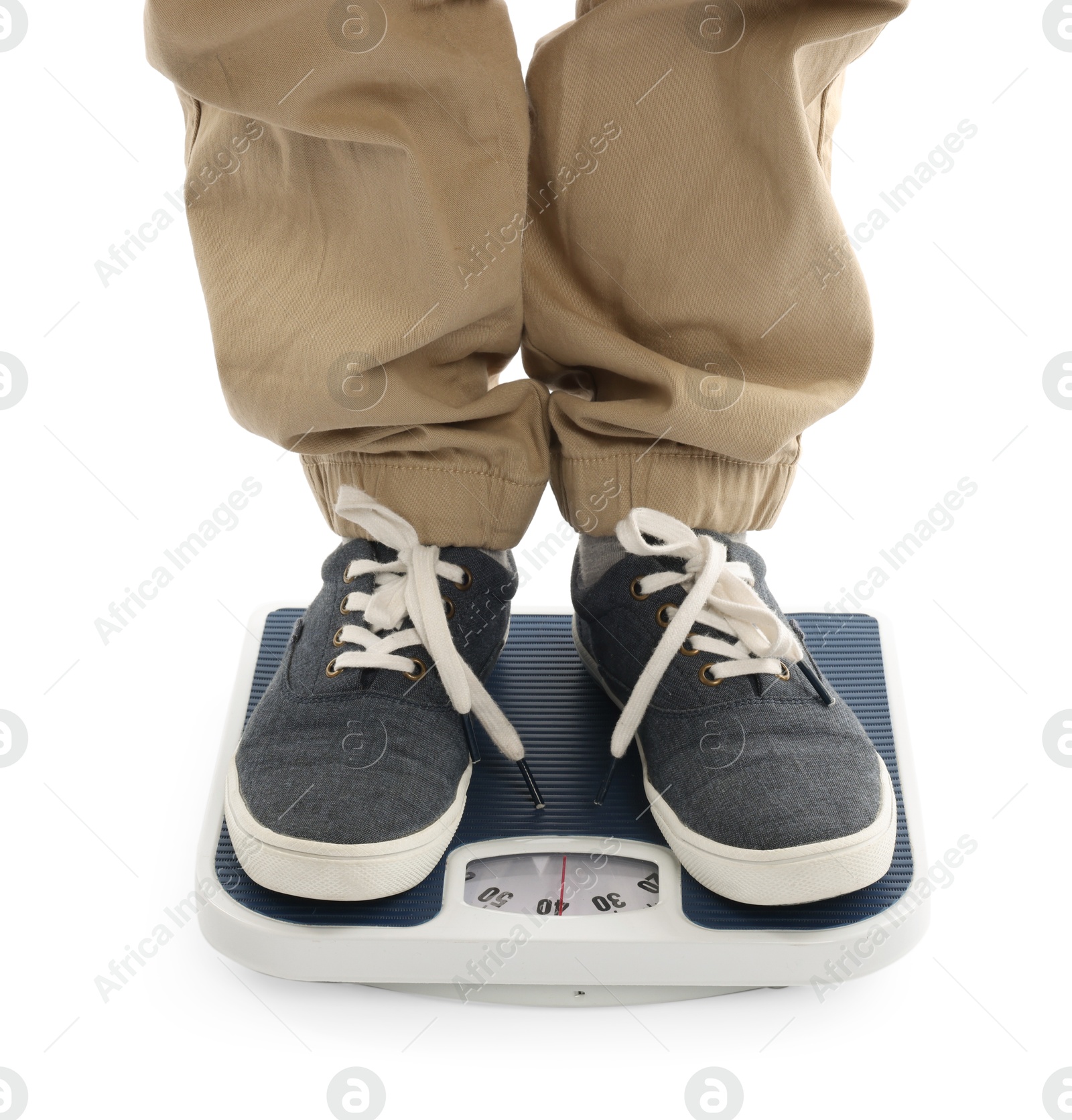 Photo of Boy standing on scales against white background, closeup