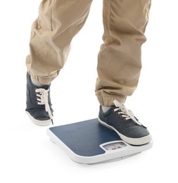 Photo of Boy standing on scales against white background, closeup