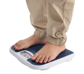 Photo of Boy standing on scales against white background, closeup