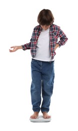 Photo of Little boy standing on scales against white background