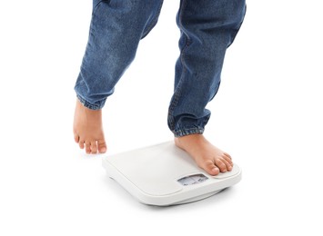 Photo of Boy standing on scales against white background, closeup