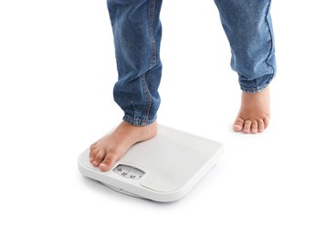 Photo of Boy standing on scales against white background, closeup
