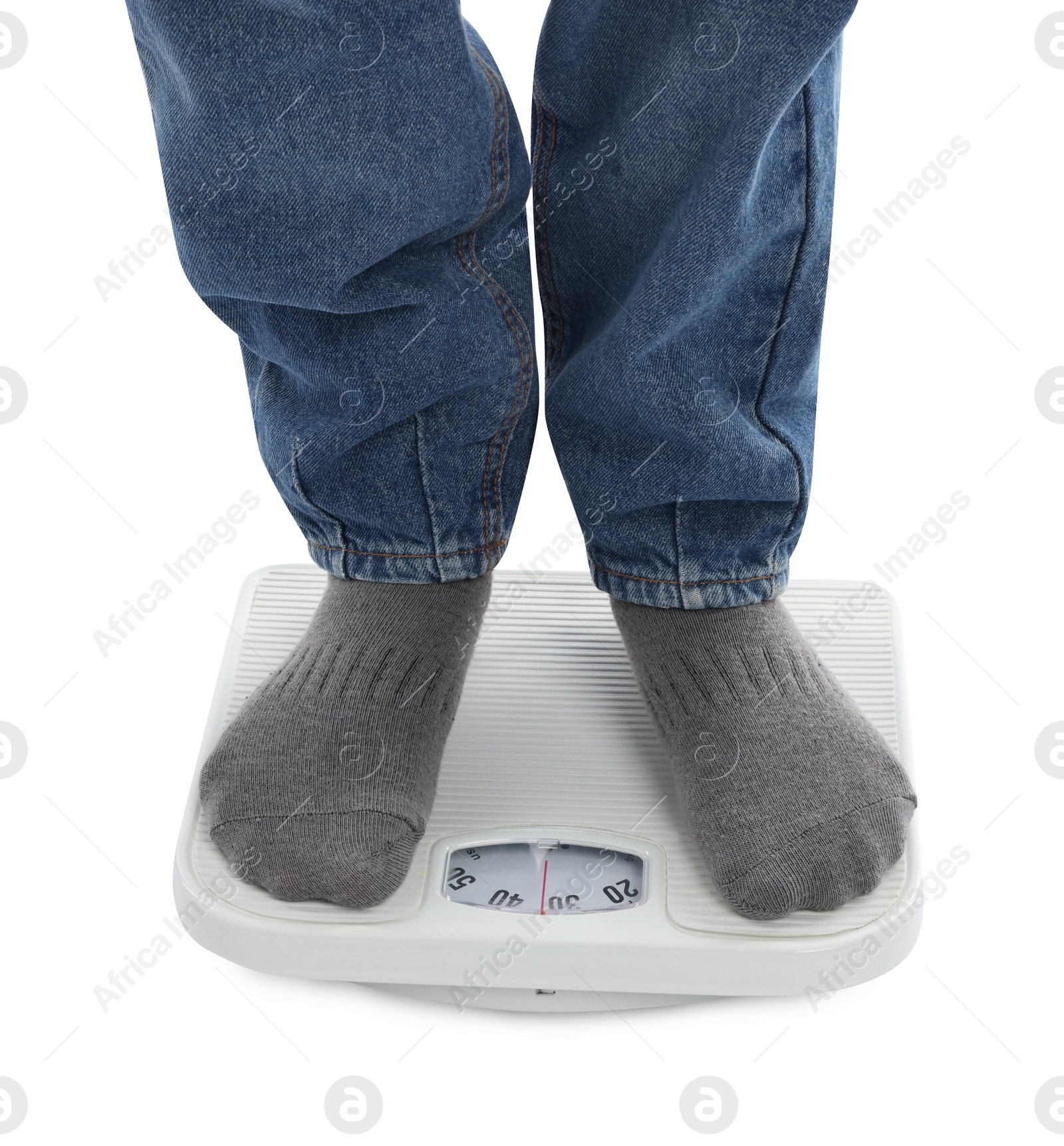 Photo of Boy standing on scales against white background, closeup
