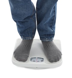 Photo of Boy standing on scales against white background, closeup