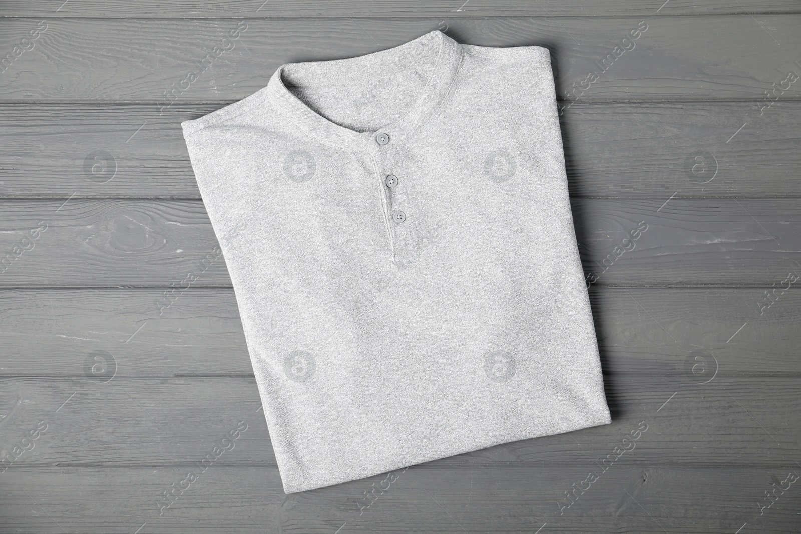 Photo of T-shirt on grey wooden table, top view. Mockup for design