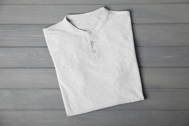 Photo of T-shirt on grey wooden table, top view. Mockup for design