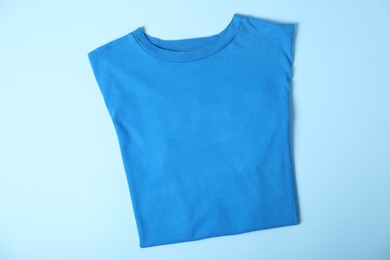 Photo of T-shirt on light blue background, top view. Mockup for design