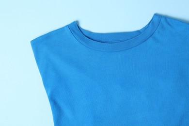 Photo of T-shirt on light blue background, top view. Mockup for design