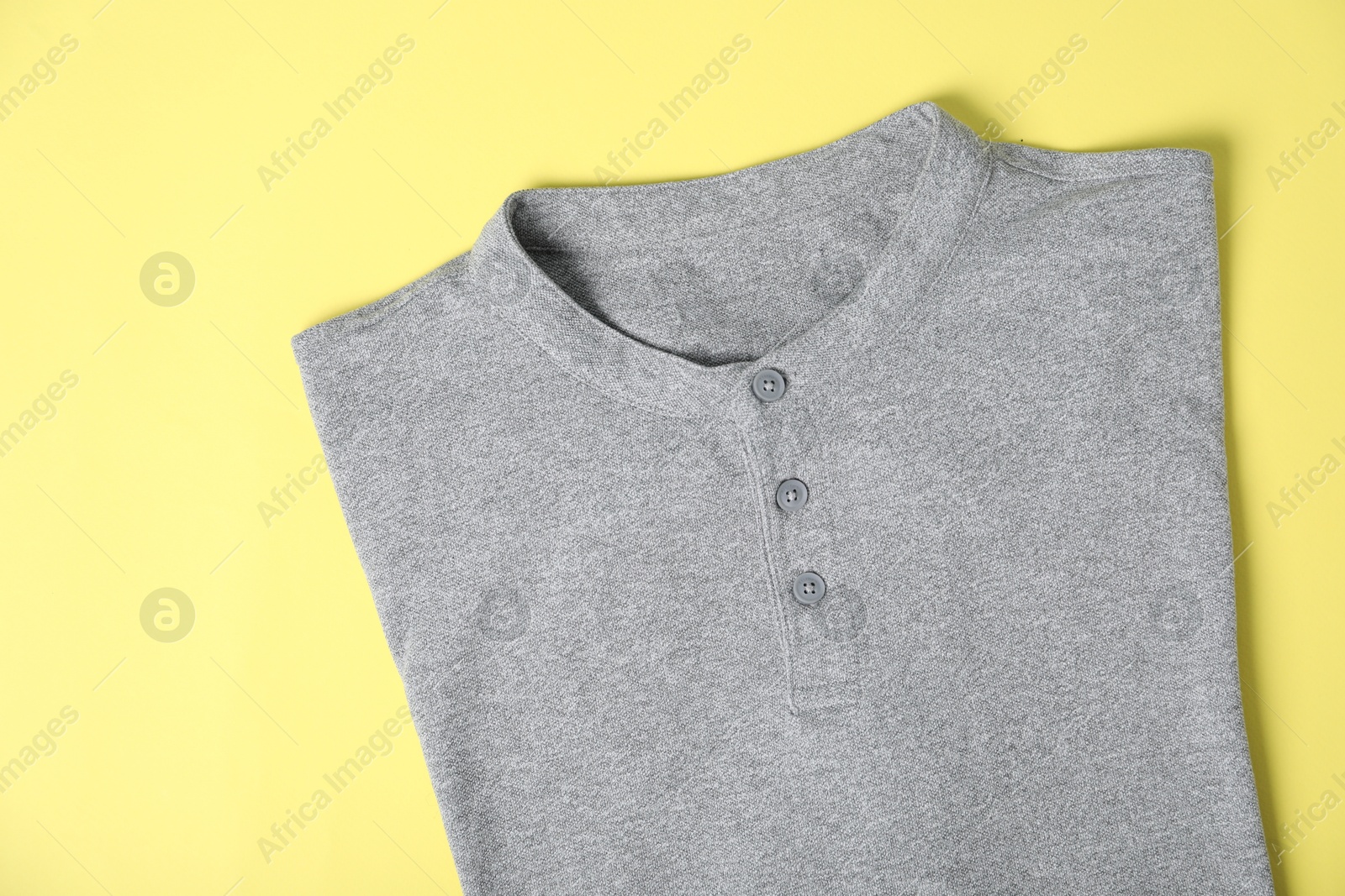 Photo of Grey t-shirt on yellow background, top view. Mockup for design