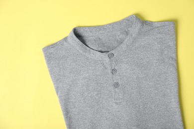 Photo of Grey t-shirt on yellow background, top view. Mockup for design