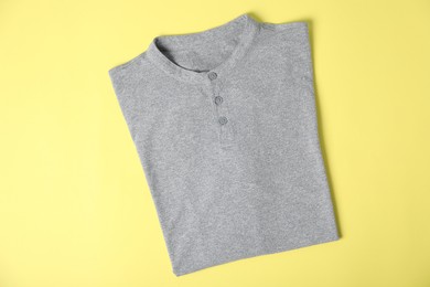 Photo of Grey t-shirt on yellow background, top view. Mockup for design