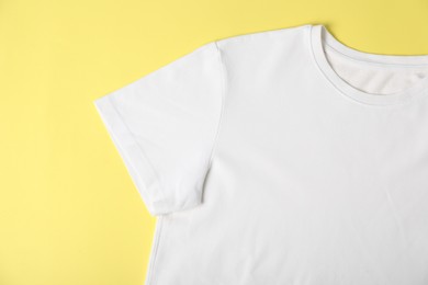 Photo of White t-shirt on yellow background, top view. Mockup for design
