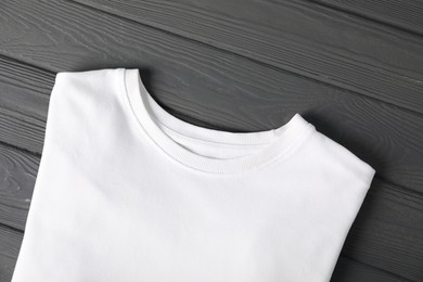 Photo of White t-shirt on grey wooden table, top view. Mockup for design