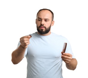Photo of Baldness problem. Worried man with comb and clump of lost hair on white background